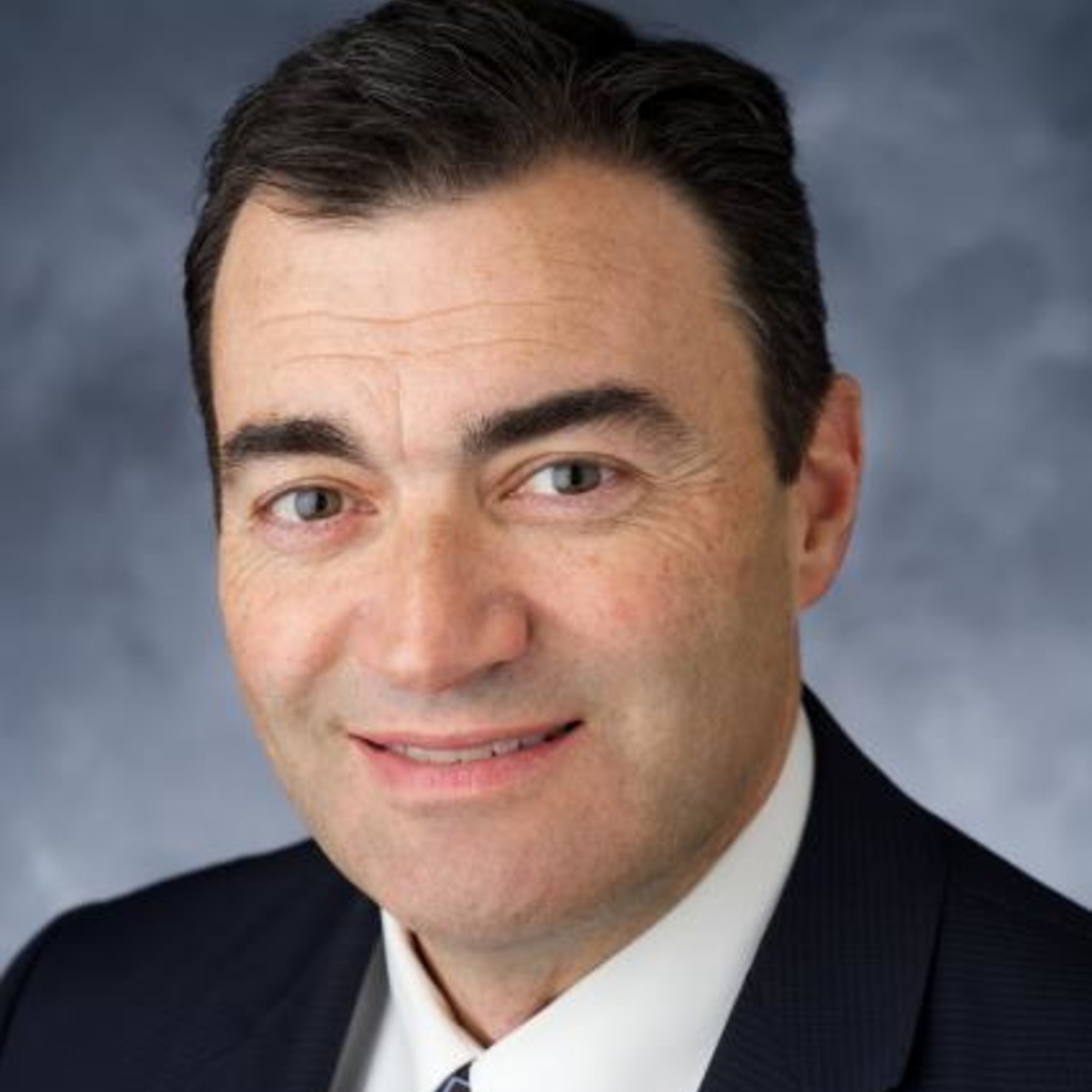 A photo of Rod Lehnertz, a man in a black suit on a blue background