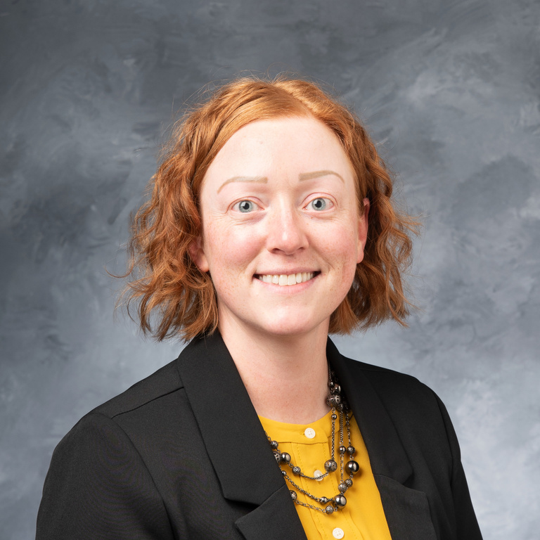 A professional photo of a woman with short, red hair