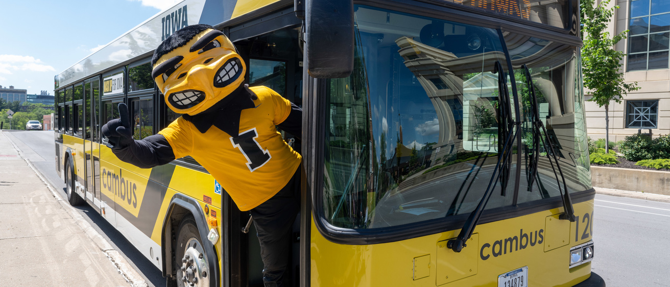 Herky hanging his body off of the entrance of the cambus 