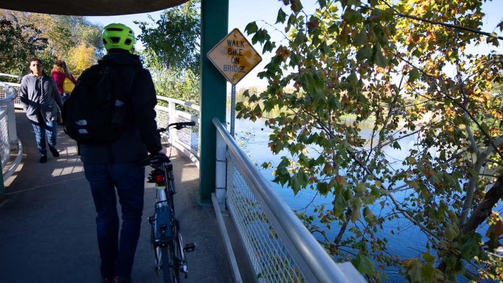 People on a bridge with a bike