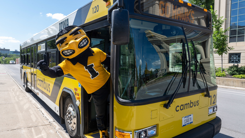 Herky hanging his body off of the entrance of the cambus 